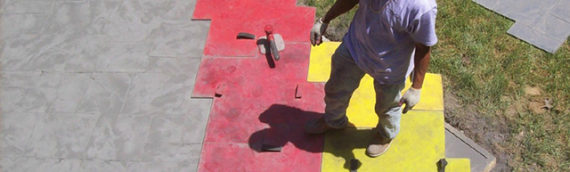 Worker stamping concrete driveway.