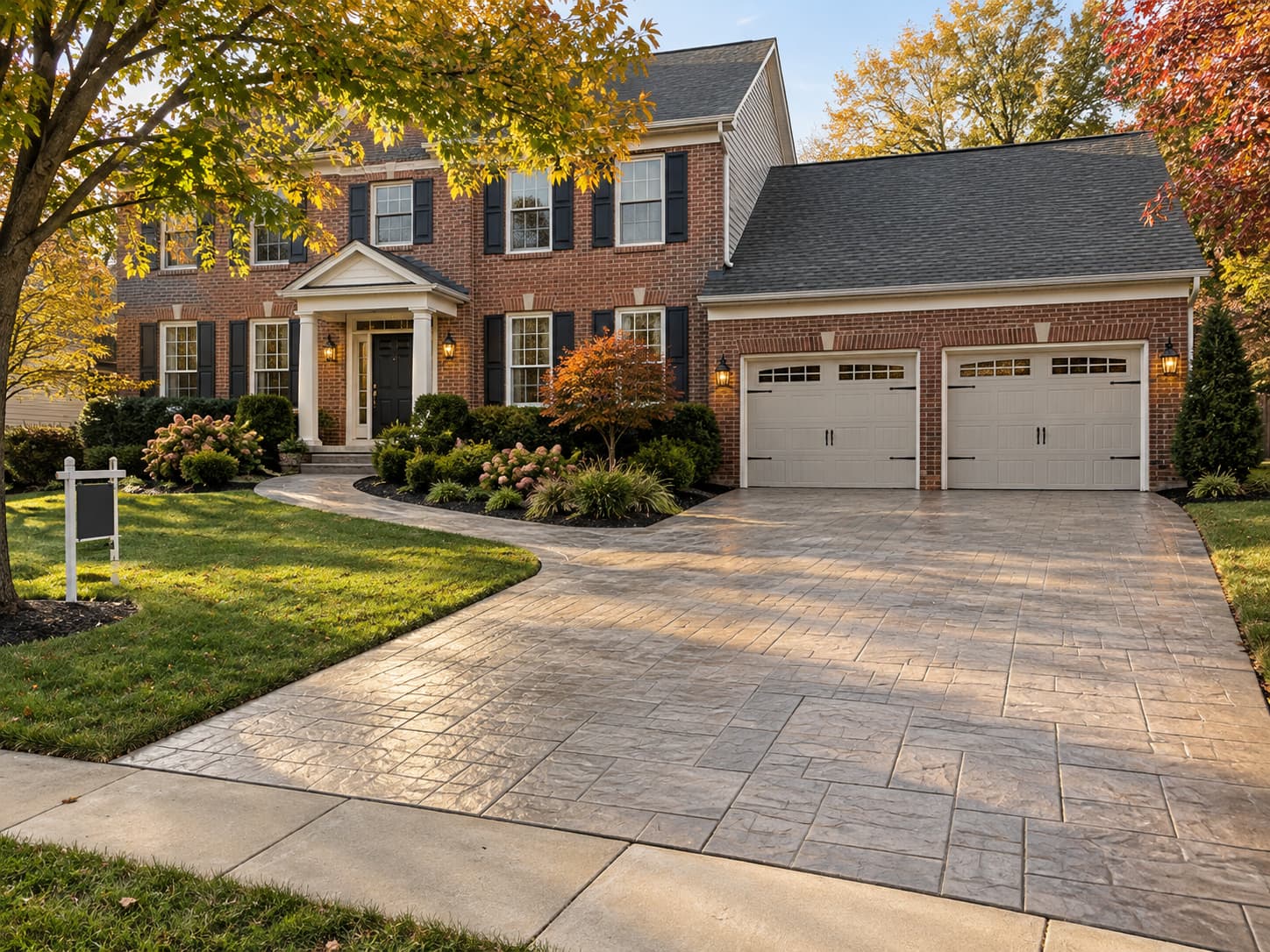 Stamped concrete driveway and curved front walkway at a brick colonial home in Maryland